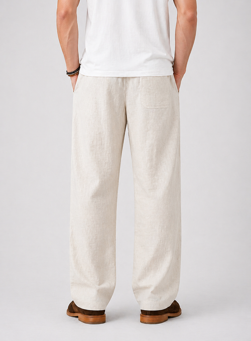 Men's beige wide-leg linen pants with drawstring waist and back pocket, worn with a white t-shirt.
