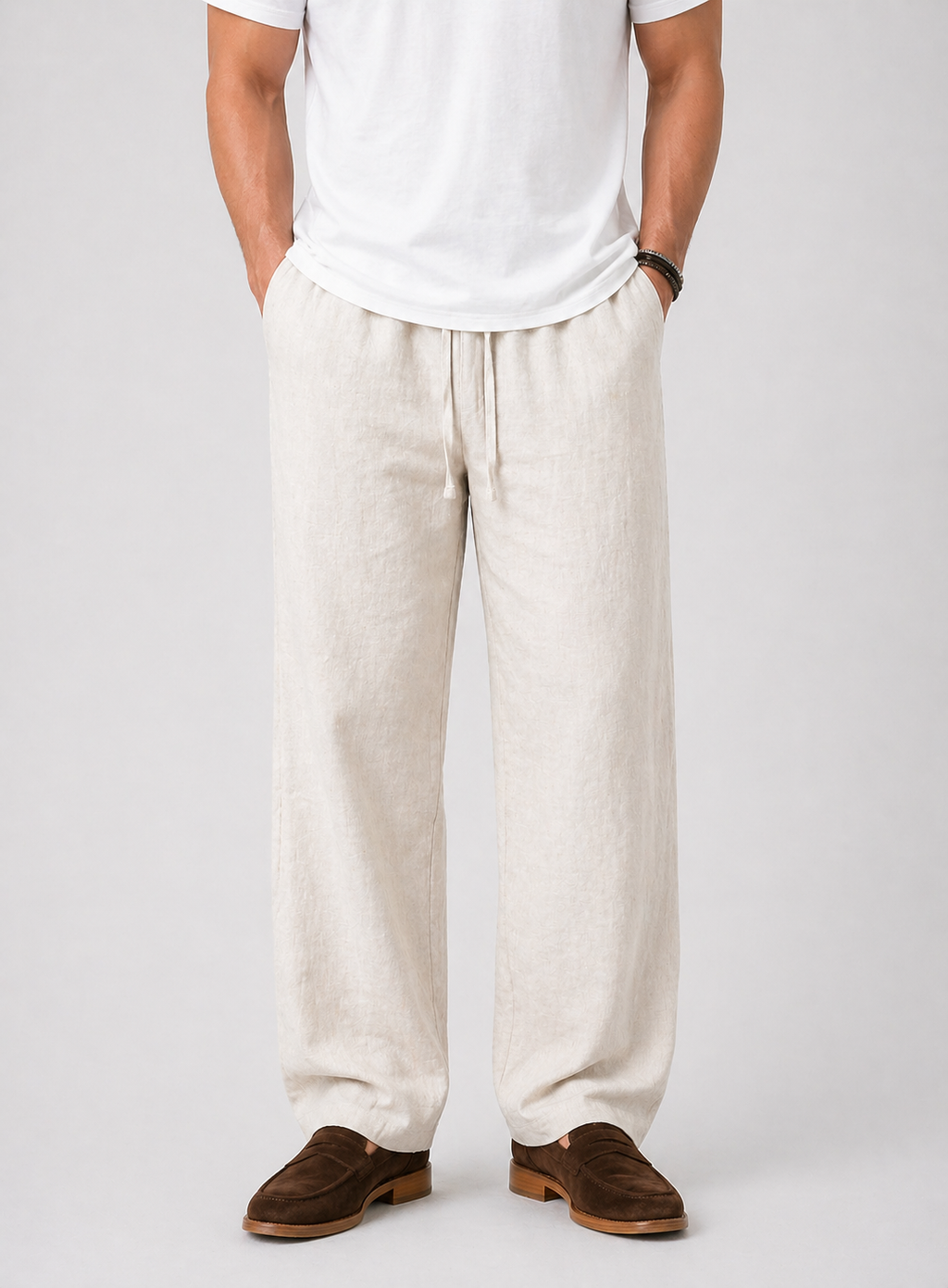 Men's natural linen wide-leg drawstring pants with side pockets, paired with a white t-shirt and brown loafers.