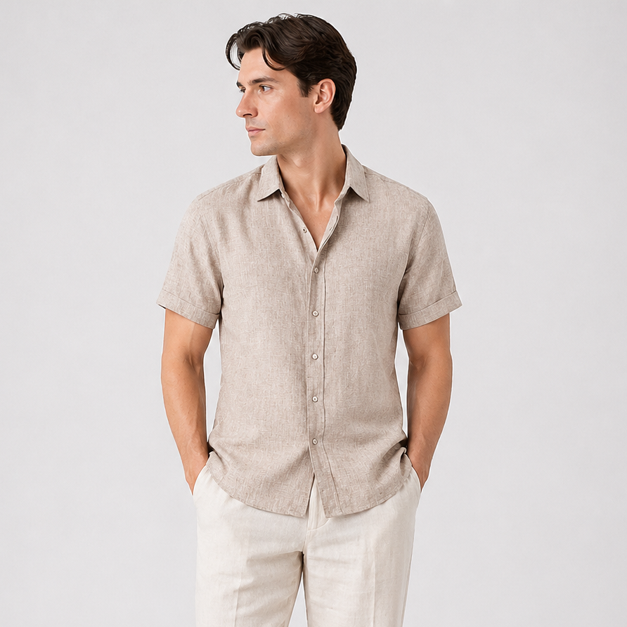 Men's classic short sleeve button-up shirt in light brown linen, paired with cream trousers and brown loafers.