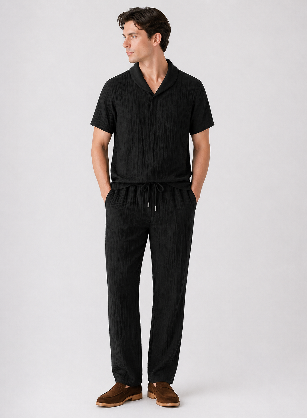 Man wearing a black outfit with a white background
