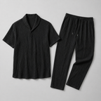 Black t-shirt and pants set on a light gray background