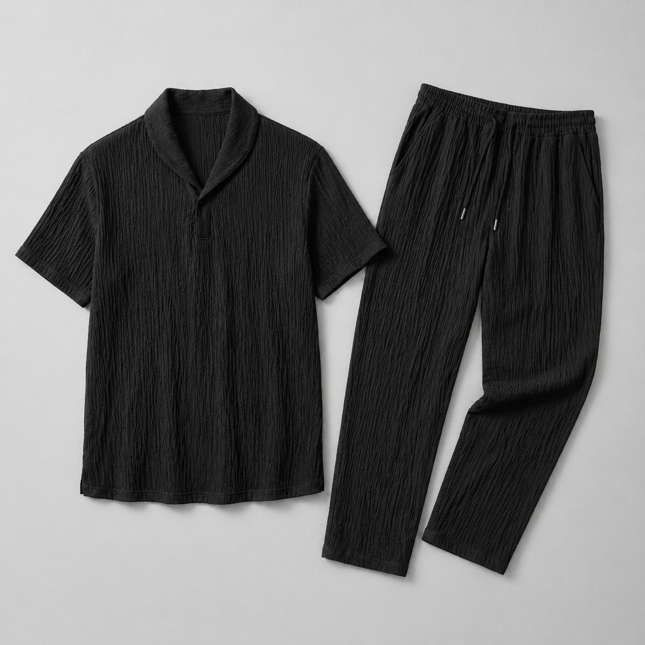 Black t-shirt and pants set on a light gray background